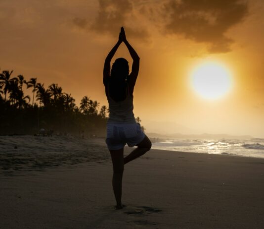 스트레스 해소를 위한 간단한 운동법 woman in white tank top and white shorts standing on beach during sunset