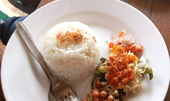 Photo by Inna Safa a white plate topped with rice and beans
