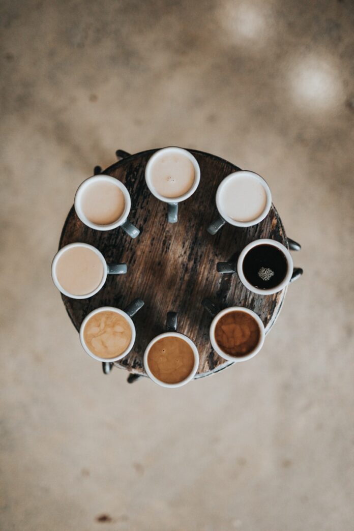 Photo by Nathan Dumlao flat lay photography of eight coffee latte in mugs on round table