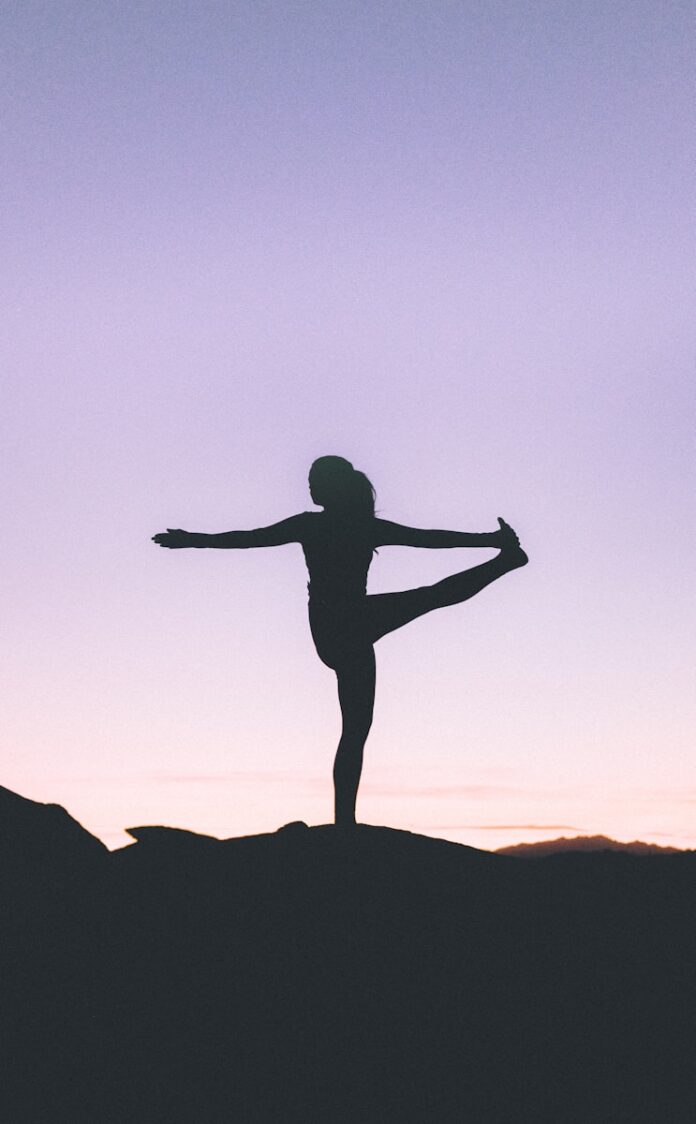 Photo by Wesley Tingey silhouette of woman doing yoga