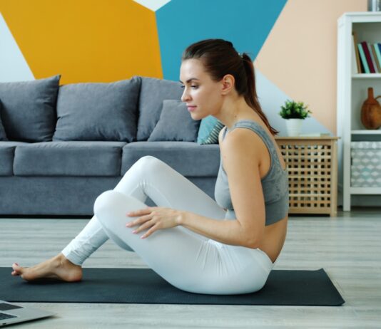 AI, 건강 관리의 일상 파트너로…똑똑하게 나를 지키는 방법 Woman exercising on yoga mat watching laptop