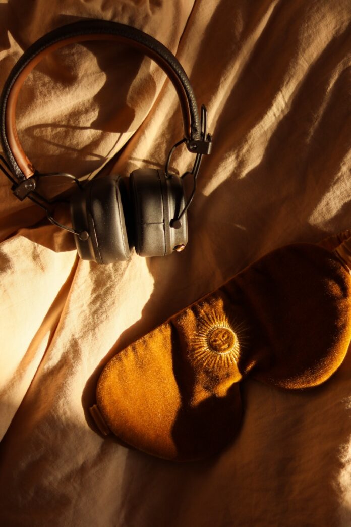 Photo by Marie G. Headphones and eye mask on wrinkled fabric